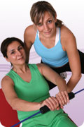 Personal Training Services : photo of personal trainer guiding the lifting form of adult woman on exercise ball.